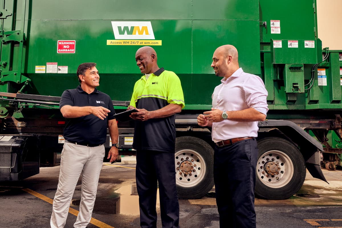 WM employees discusses compactor rental with customer.
